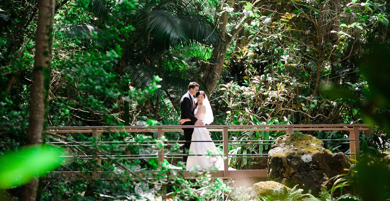 Bride and Groom on a bridge at botanical gardens on Kauai