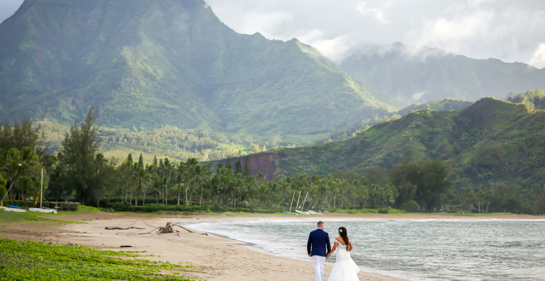 Bride and groom enjoy the beautiful mountain views at Hanalei Bay on Kauai.