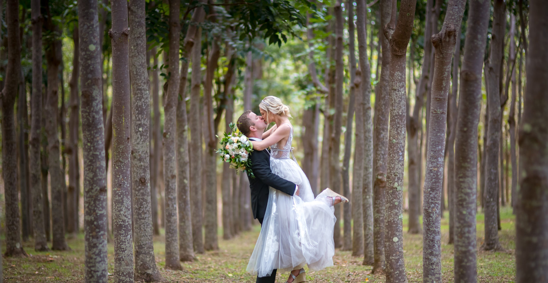 Newlyweds share their first kiss sealing their vows at a Botanical Garden wedding on Kauai.