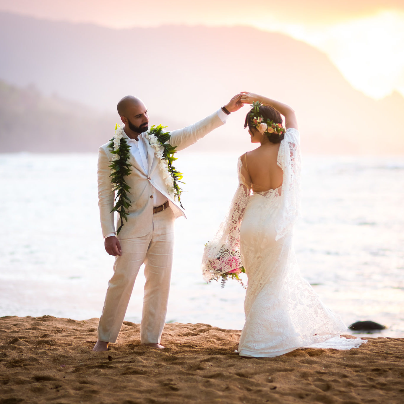 Bride and groom first dance on the beach as sunset